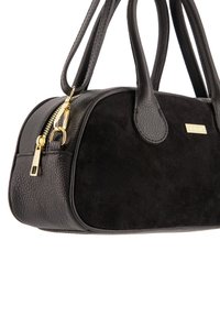 Black handbag featuring a combination of textured leather and suede, gold zipper hardware, and dual stitched handles for carrying.