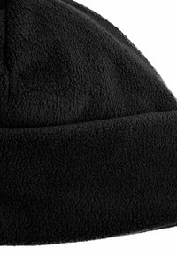 Bonnet en polaire noir avec une texture douce, un dessus arrondi et un revers replié à la base. Aucun motif ni pièce métallique visible.