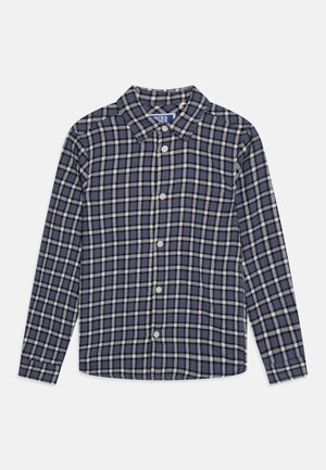 Camisa de cuadros en tonos navy y crema, estilo abotonado, con cuello y mangas largas. Confeccionada en un tejido texturizado, presenta un patrón uniforme en toda la prenda.