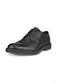 Chaussure habillée brogue en cuir noir avec motif à bout ailé, détails perforés et lacets noirs, présentée légèrement inclinée sur fond blanc.
