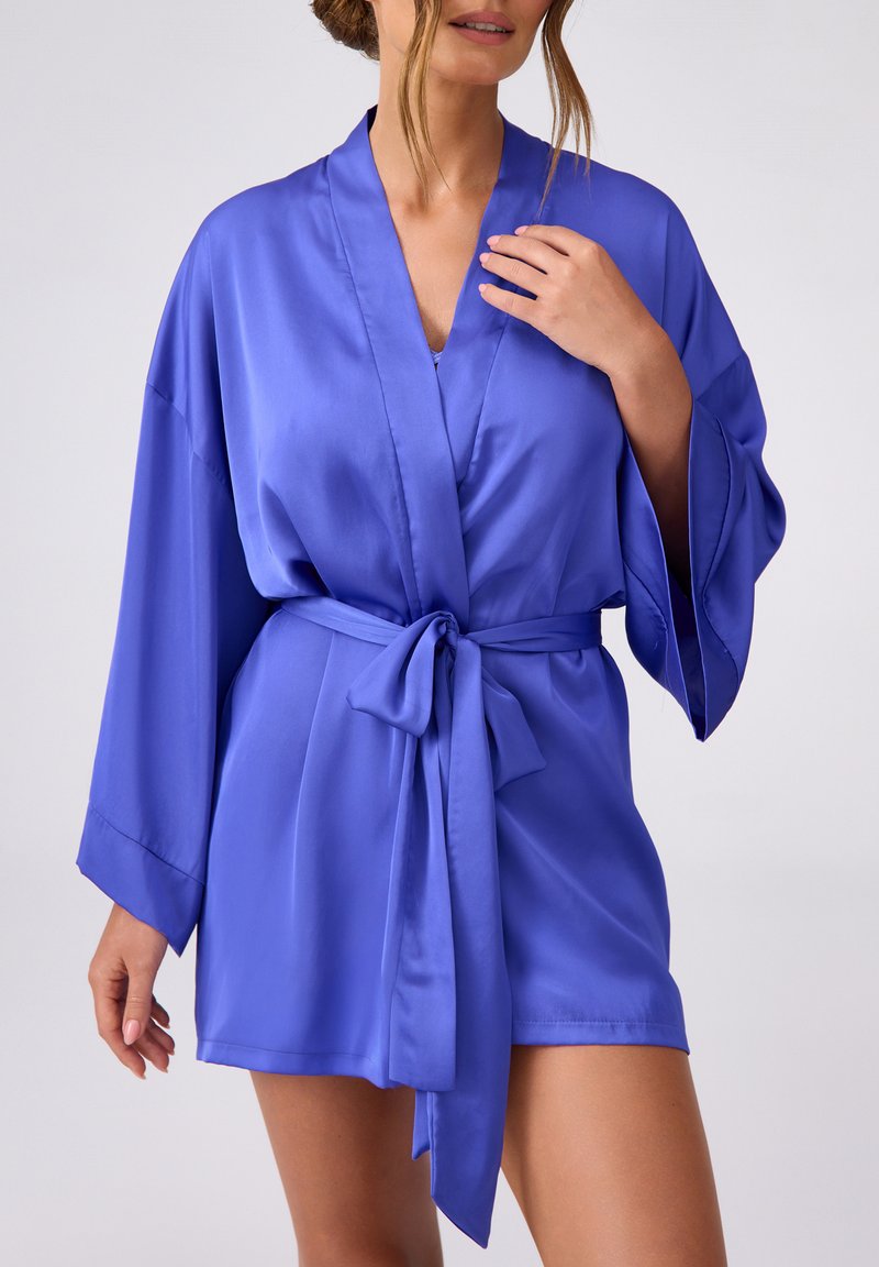 Fioletowy satynowy szlafrok z rękawami w stylu kimono, z paskiem w talii. Gładka tekstura i długość do kolan, z głębokim dekoltem w kształcie litery V.