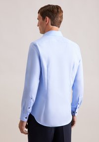 Lichtblauw shirt met lange mouwen, van een katoenmix, gladde textuur, klassieke kraag, ronde zoom, knoopaccenten op de manchetten.