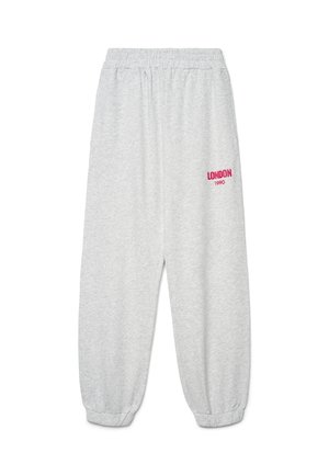 Pantalon de survêtement gris clair avec taille et poignets élastiques, arborant le texte rouge "LONDON 1990" sur la cuisse gauche.