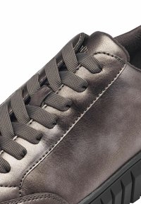 Hall grey nahast spordijalats, millel on sile lacing süsteem, pehmendatud krae ja tekstureeritud kummist välistald. Omab peent metallist sära ja õmblusdetailide elemendid.