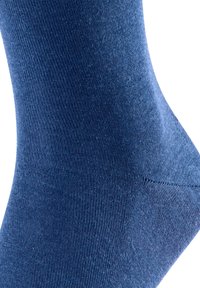 Sötétkék zokni, sima anyagból, bordázott textúrával és varrás nélküli kialakítással, ívelt formával a bokánál.