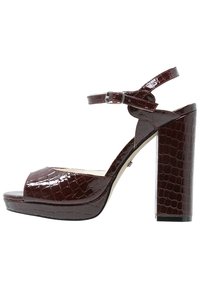 Burgundy high-heeled sandal with a crocodile pattern, open toe, ankle strap, and a thick block heel, featuring a shiny patent finish.