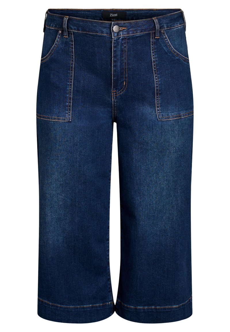 Los culottes de mezclilla azul oscuro presentan una cintura alta, dos bolsillos frontales, costuras visibles y un diseño de pierna ancha que termina por debajo de la rodilla.