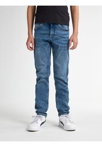 Pantalones vaqueros de mezclilla azul claro con corte recto, cinco bolsillos y costuras en contraste, combinados con zapatillas blancas con detalles en negro.