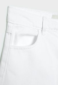 I jeans in denim bianco presentano una tasca frontale, una vita cucita e linee pulite. Il tessuto ha una texture liscia senza motivi visibili.