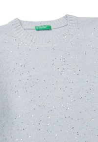 Světle modrý pletený svetr s žebrovaným kulatým výstřihem a rozptýlenými stříbrnými flitry, s označením "United Colors of Benetton" v zelené barvě.