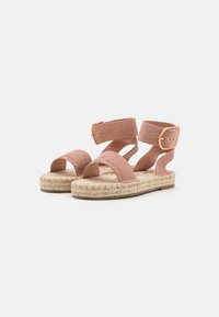 Sandali espadrilles in suede rosa con due cinturini, un accento con fibbia e suola in juta. Presentano una superficie testurizzata e un design aperto.