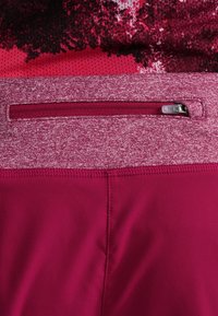 Mallas deportivas burdeos con una cinturilla jaspeada y un bolsillo con cremallera. Textura suave, tejido elástico y diseño que absorbe la humedad.