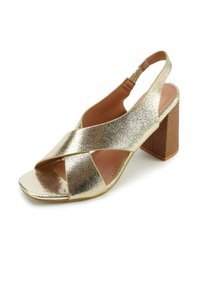 Gouden slingback sandaal met een gestructureerde metallic afwerking, open teen, gekruiste bandjes en een dikke houten blokhak.