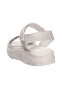 Sandalias ajustables de color gris claro con correas texturizadas, una plantilla acolchada y una suela gruesa y contorneada. Cuenta con una correa trasera para mayor apoyo.