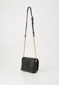 Zwarte leren crossbody tas met een rechthoekige vorm, gestructureerd oppervlak, gouden kettingstrap en een kleine merkcharme eraan bevestigd.