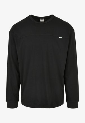 Tricou negru cu mânecă lungă, din bumbac, cu decolteu rotund și o mică etichetă cu logo pe pieptul stâng. Textură netedă.