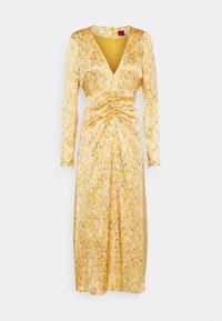Gul klänning med lång ärm och djup V-ringning, med rynkad midjedetalj, mönstrad med svarta och gyllene accenter, tillverkad av ett glänsande, texturerat material.