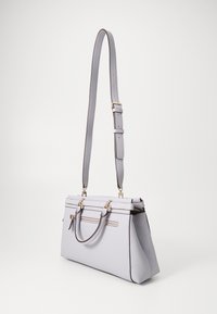 Borsa a tracolla grigio chiaro realizzata in cuoio testurizzato, con una forma strutturata, doppio manico, tracolla regolabile e dettagli in hardware color oro.