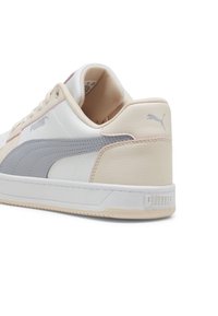 Puma-sneakers i beige, vitt och grått läder; lågskuren design med texturerade detaljer och en hållbar gummisul. Logotyp på hälen.