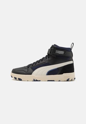 High-top Puma sneaker in black and navy with white stripe, beige sole with blue patterns, velcro strap, and pull tab on a white background.