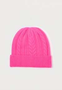Heldere roze gebreide beanie met een omgevouwen geribbelde rand en verticale kabelbreipatronen, plat op een witte ondergrond gelegd.