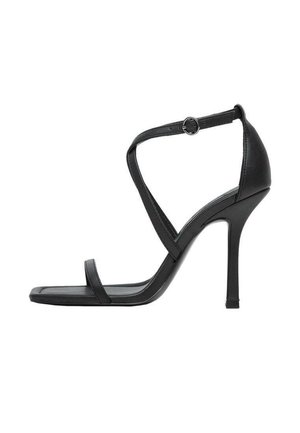 Sort højhælet sandal med tynde remme, ankelspænde, åben tå og en slank stilethæl på en hvid baggrund.