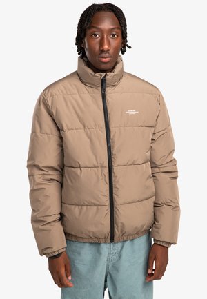 Brown puffer jacket with high collar, zip closure, and elastic cuffs. Features a quilted design and a small logo on the chest.