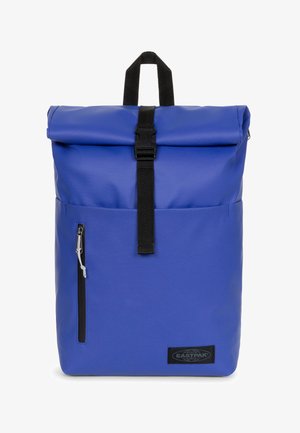 Sac à dos roll-top bleu fabriqué en matériau durable, doté d'une sangle noire et d'une fermeture à boucle, d'une poche zippée sur le côté et d'un patch de logo Eastpak.