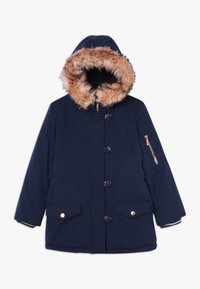 Abrigo de invierno azul marino con capucha forrada de piel, cierre de botones y cremallera, dos bolsillos delanteros con solapa y botones, y un bolsillo con cremallera en la manga izquierda.