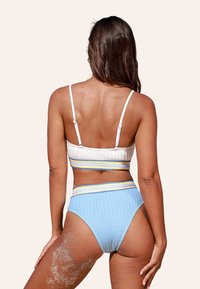 Set di bikini a due pezzi composto da un top bianco texturizzato con spalline regolabili e slip a vita alta di colore azzurro chiaro con righe gialle e blu.