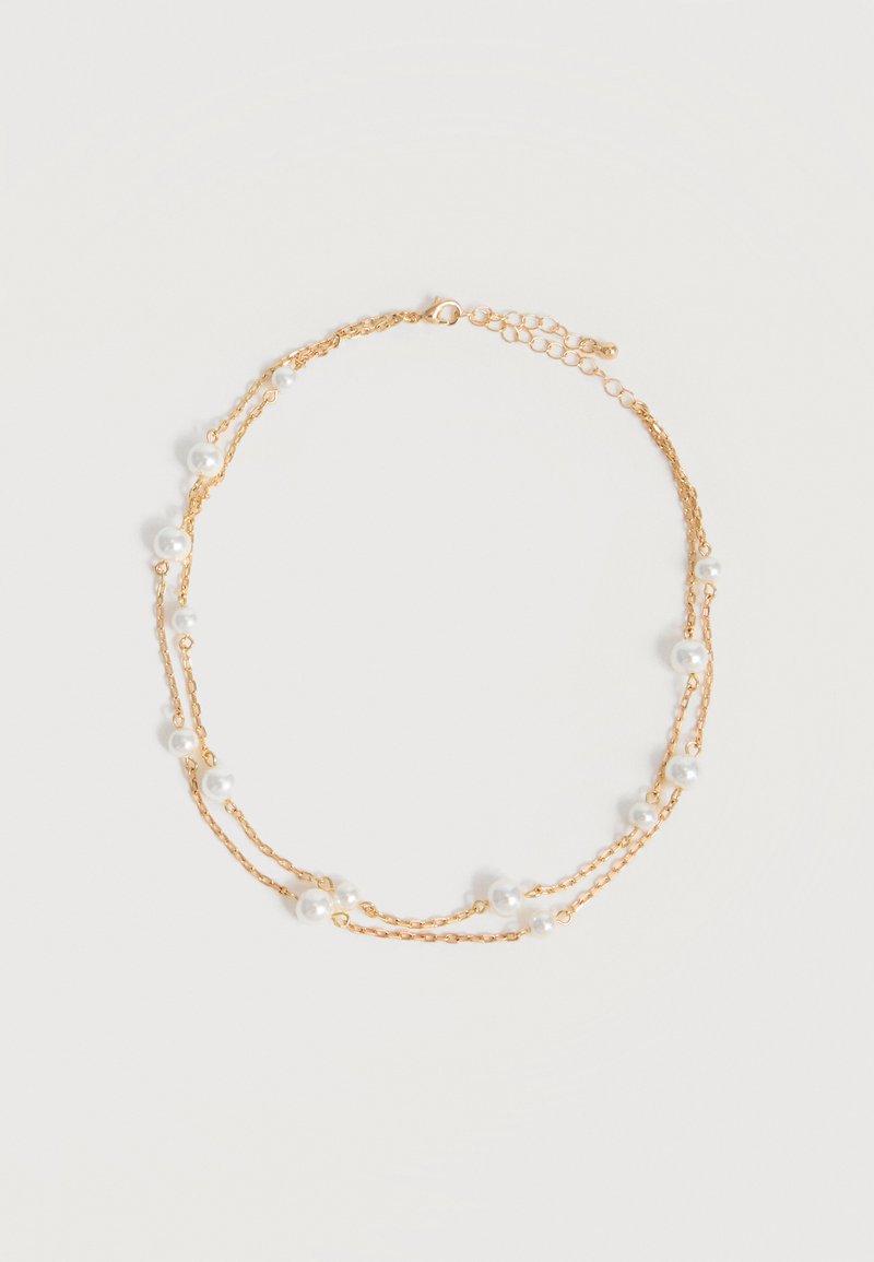 Λεπτό διπλό χρυσό κολιέ με ομοιόμορφα κατανεμητές μικρές λευκές πέρλες σε απλό ανοιχτό φόντο.