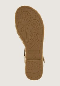 Unteransicht einer beigen Schuhsohle mit strukturiertem Muster, das blumige Designs und wellenförmige Linien zeigt, mit der Marke "TOM TAILOR", Größe 40.