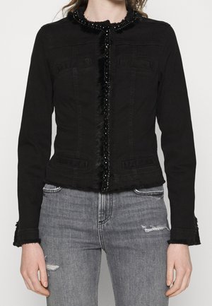 Giacca in denim nera con design aderente, dettagli in perline e pelliccia sintetica lungo il centro e al colletto, dotata di due tasche frontali e polsini sfrangiati.