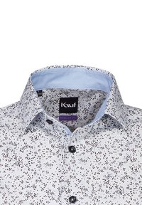 Camicia con bottoni caratterizzata da un tessuto bianco con un motivo a foglie nere, un colletto azzurro chiaro e bottoni neri per la chiusura. Design a vestibilità regolare.