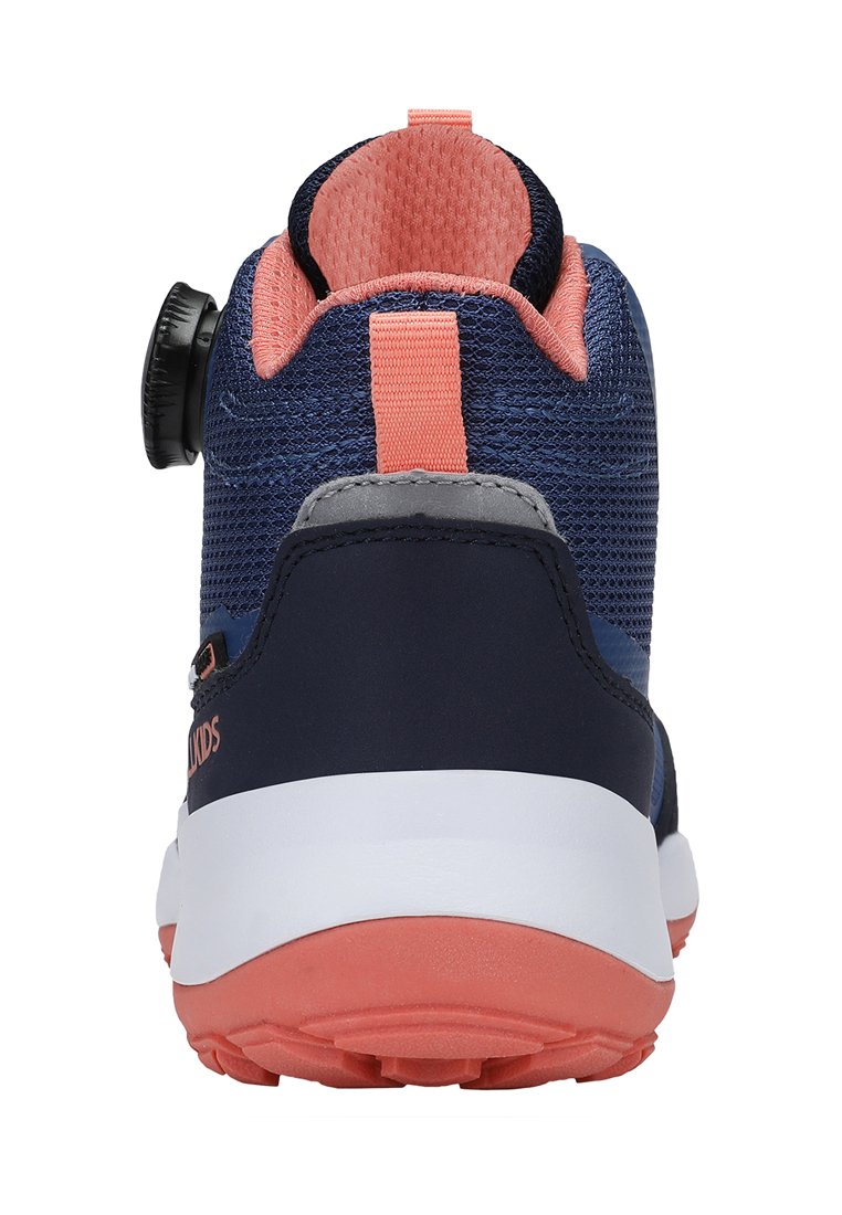 Zapatilla azul marino con parte superior de malla, acentos rosa y suela blanca. Presenta un sistema de cordones circular y una tapa de talón en contraste. Diseño texturizado.