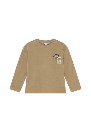 Camisa beige de manga larga con dos pequeños parches en el lado izquierdo del pecho, uno ovalado con texto y otro rectangular con un diseño de snowboard.
