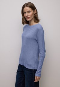 Lichtblauwe geribbelde trui met lange mouwen, voorzien van een ronde hals en een losse pasvorm, gemaakt van een zacht gebreid materiaal. Gecombineerd met donker denim.