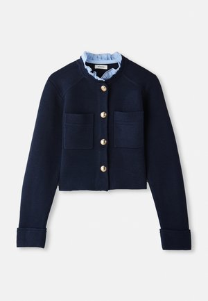 Navy cropped cardigan with two front pockets, gold buttons, and a light blue ruffled collar. Made of ribbed texture material.