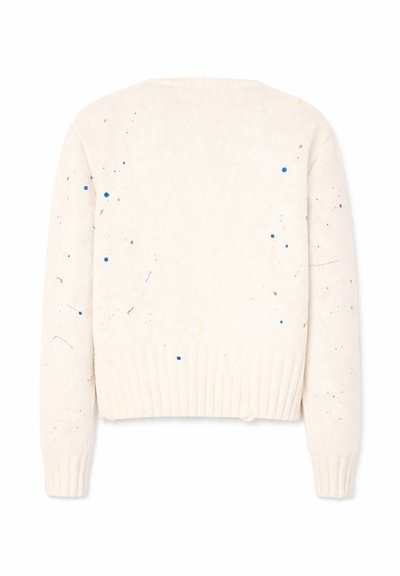 Maglione bianco lavorato a maglia con maniche lunghe e piccoli motivi a schizzi di vernice blu, grigia e gialla sparsi sul tessuto.