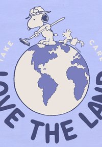 Camiseta gráfica de color púrpura claro con Snoopy limpiando la Tierra con un pincel; incluye el texto "AMAA EL PLANETA" en letras grandes.