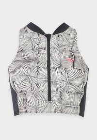 Top court sans manches noir et blanc avec un motif de feuilles abstrait et une fermeture éclair à l'avant, avec un petit logo rose sur la poitrine.