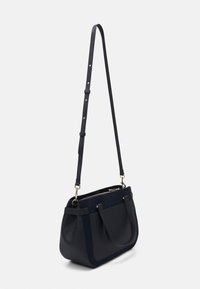 Borsa a spalla in pelle e suede blu scuro con hardware dorato e tracolla lunga regolabile, dotata di tasca frontale e chiusura a zip.