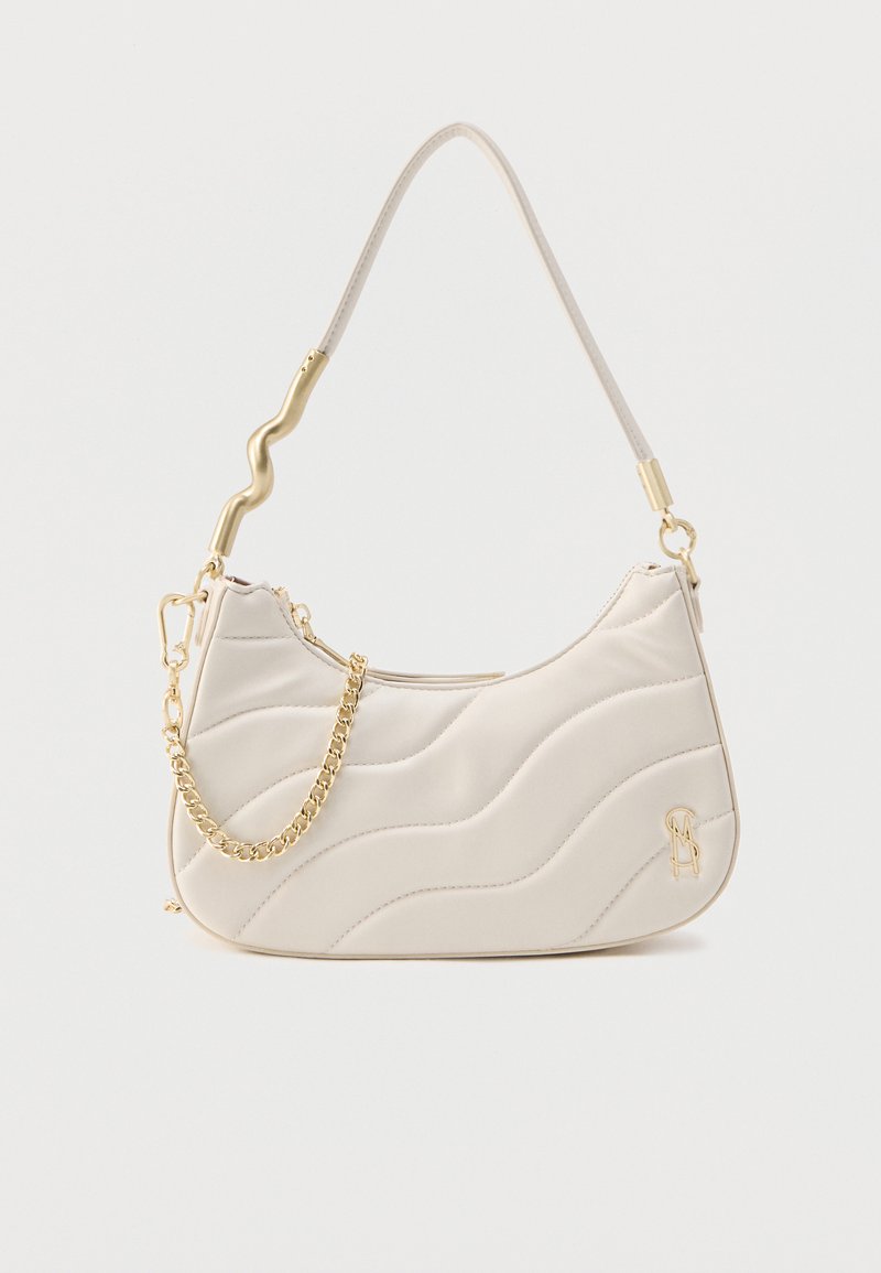 Κρεμ τσάντα ώμου με καπιτονέ ύφασμα, κυματιστή αλυσίδα σε χρυσό τόνο, καμπυλωτό φερμουάρ στην κορυφή και χρυσό λογότυπο στην κάτω δεξιά γωνία.