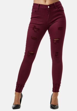 Jean skinny bordeaux avec des patchs déchirés et des ourlets volants. Fabriqué en denim, il possède une fermeture à bouton classique à l'avant et des poches.