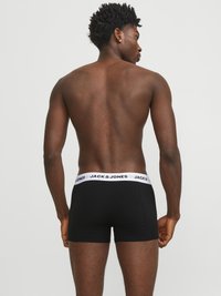 Crne bokserice izrađene od mekog materijala s bijelim elastičnim pojasom na kojem se nalazi logo "JACK & JONES". Strašnja strana modela prikazuje usklađenost.