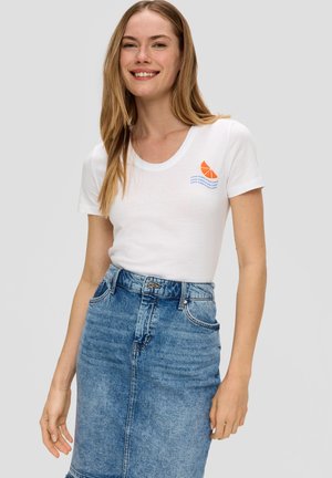 T-shirt en coton blanc avec un décolleté en rondeur, orné d'un graphique orange et bleu représentant une tranche d'agrumes, associé à une jupe crayon en denim bleu.