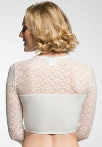 Biele crop top s dlhými rukávmi a zložitou čipkovou aplikáciou. Hladký základný materiál s priliehavým strihom. Zadný pohľad zobrazuje čipkový detail.