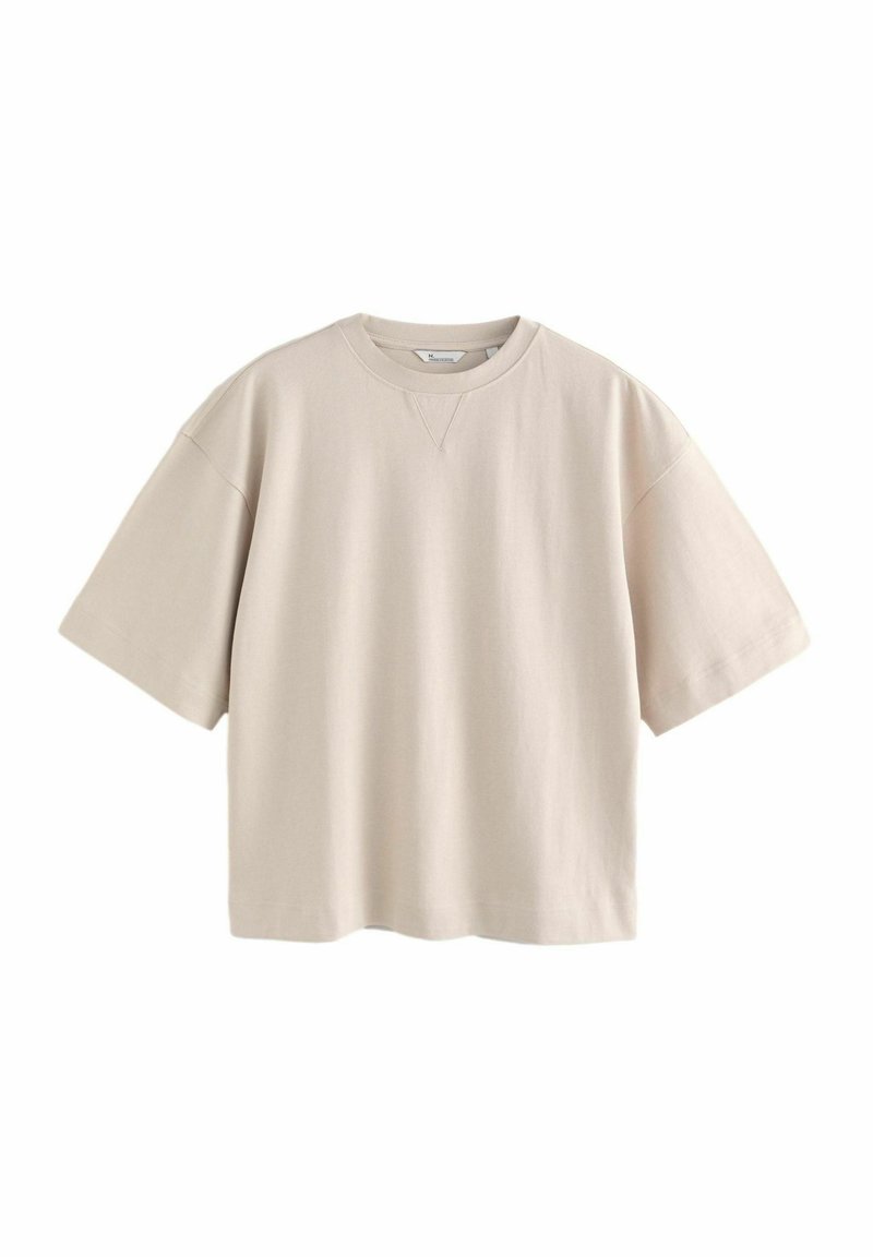 Beżowa bawełniana oversize t-shirt z okrągłym dekoltem, krótkimi rękawami i prostym dołem. Posiada subtelny detal przeszycia przy dekolcie.