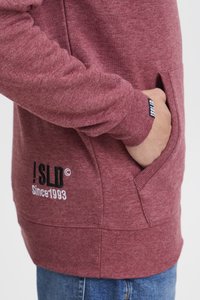 Bordowa bluza z kapturem, wykonana z miękkiego materiału, z kieszenią kangurką, ściągaczami na rękawach oraz logo "!SLD Since 1993" w kontrastowych kolorach.