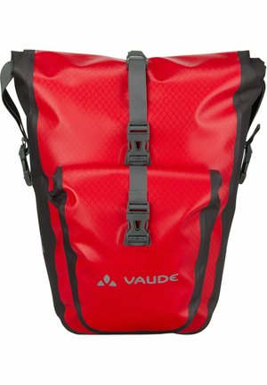 Sac à dos imperméable rouge avec une surface texturée, des accessoires en acier gris et des sangles réglables. Il dispose d'une poche avant et du logo Vaude.